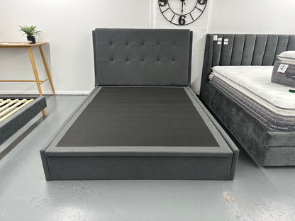 Solid upholstered grey bed frame with gaslift storage.