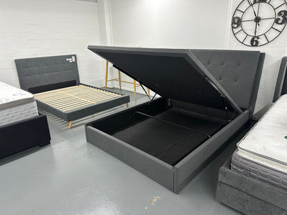 Solid upholstered grey bed frame with gaslift storage.