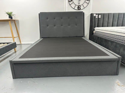 Solid upholstered grey bed frame with gaslift storage.