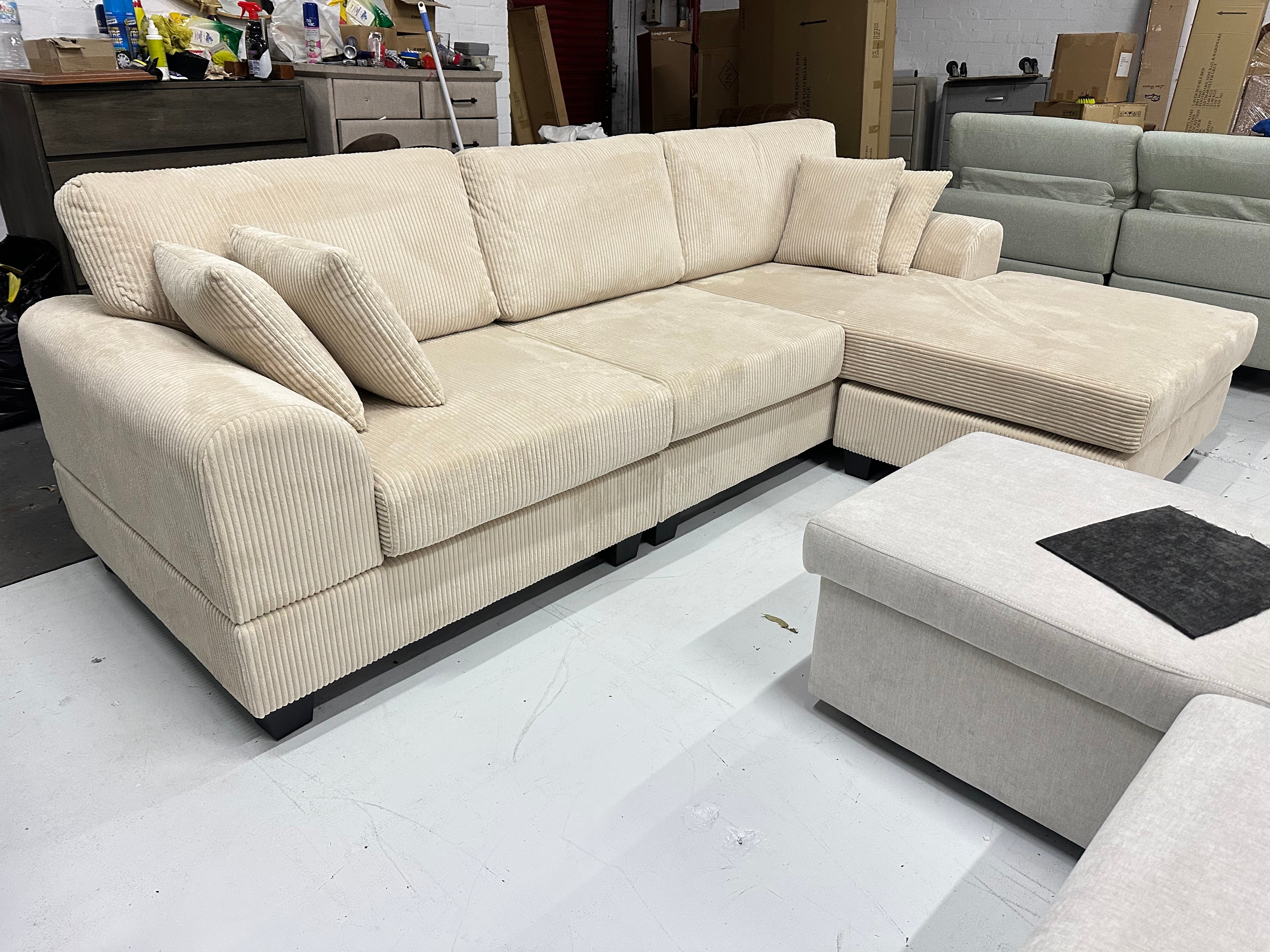 Cream color corduroy sofa and cream bed frame with mattress
