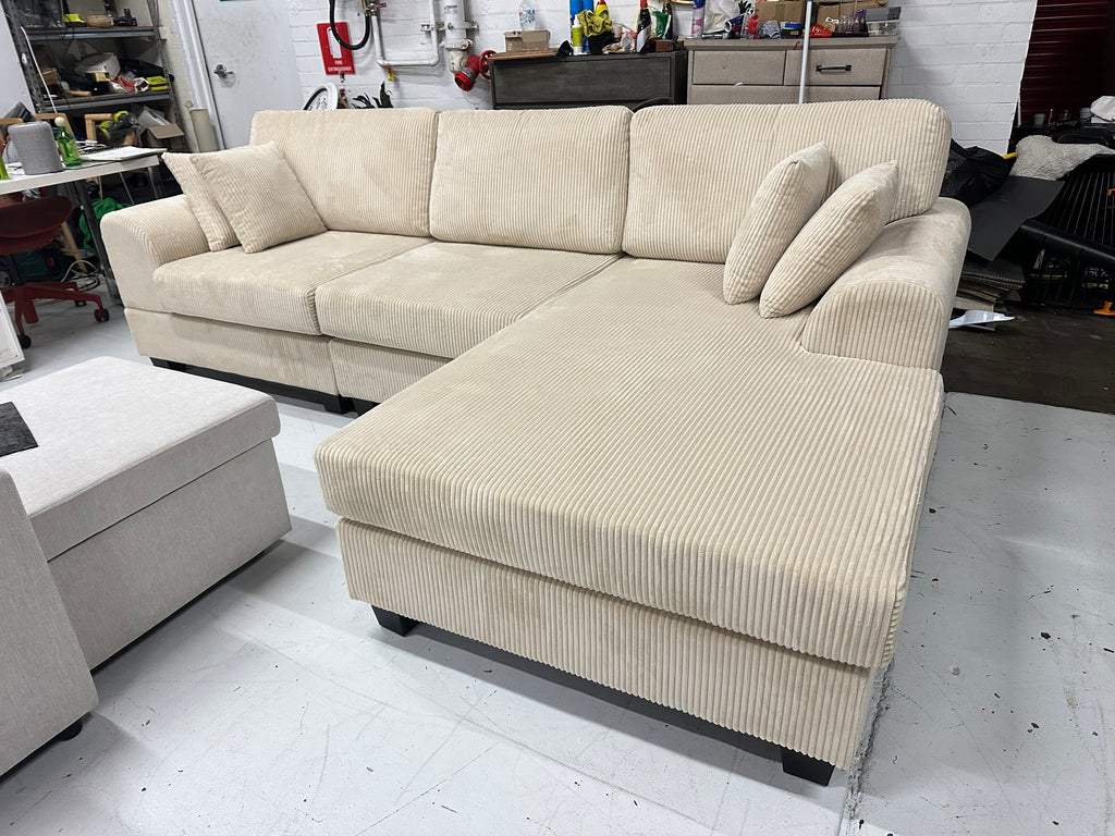 Cream color corduroy sofa and cream bed frame with mattress