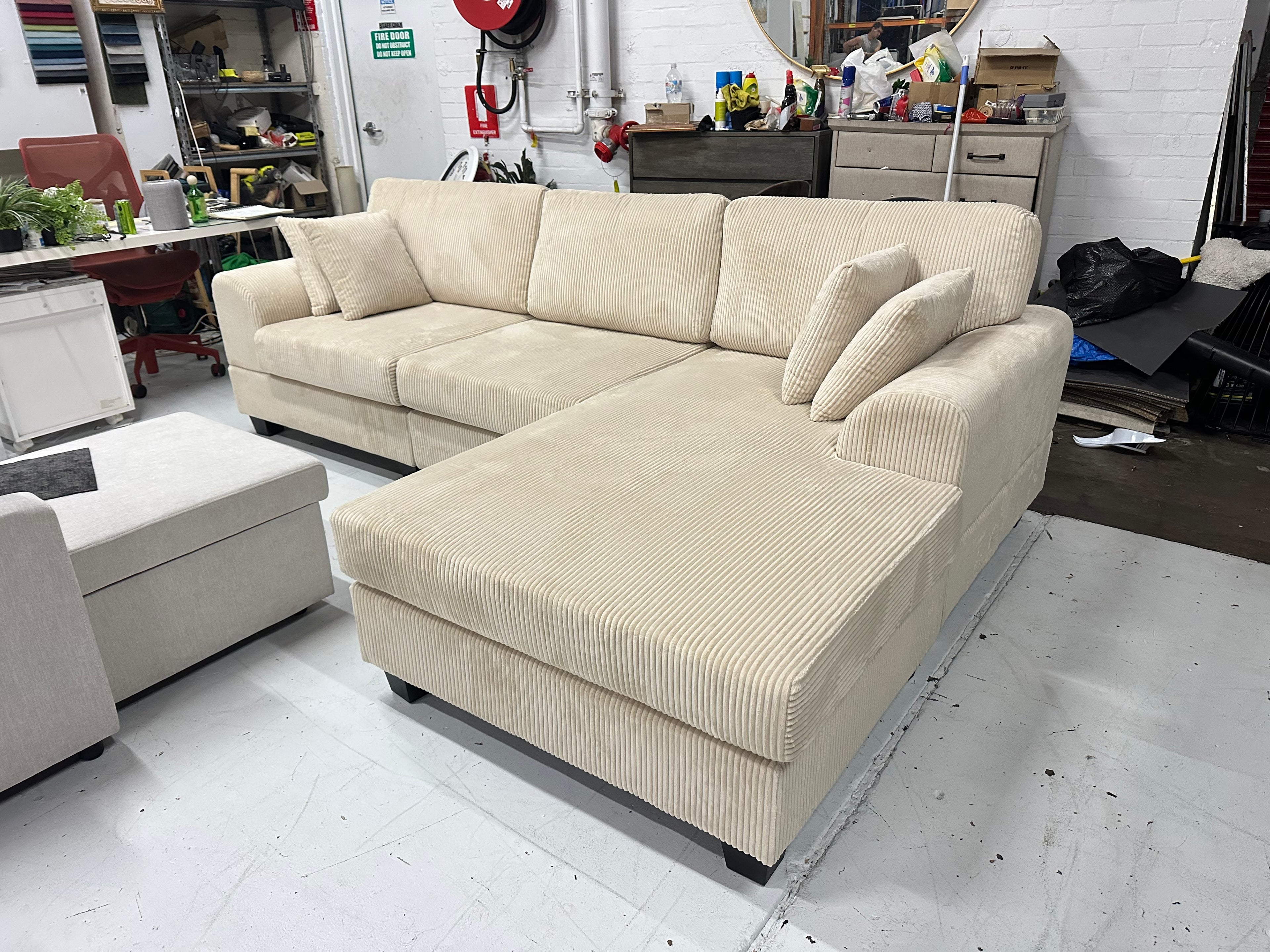 Cream color corduroy sofa and cream bed frame with mattress