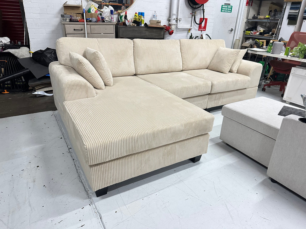 Cream color corduroy sofa and cream bed frame with mattress