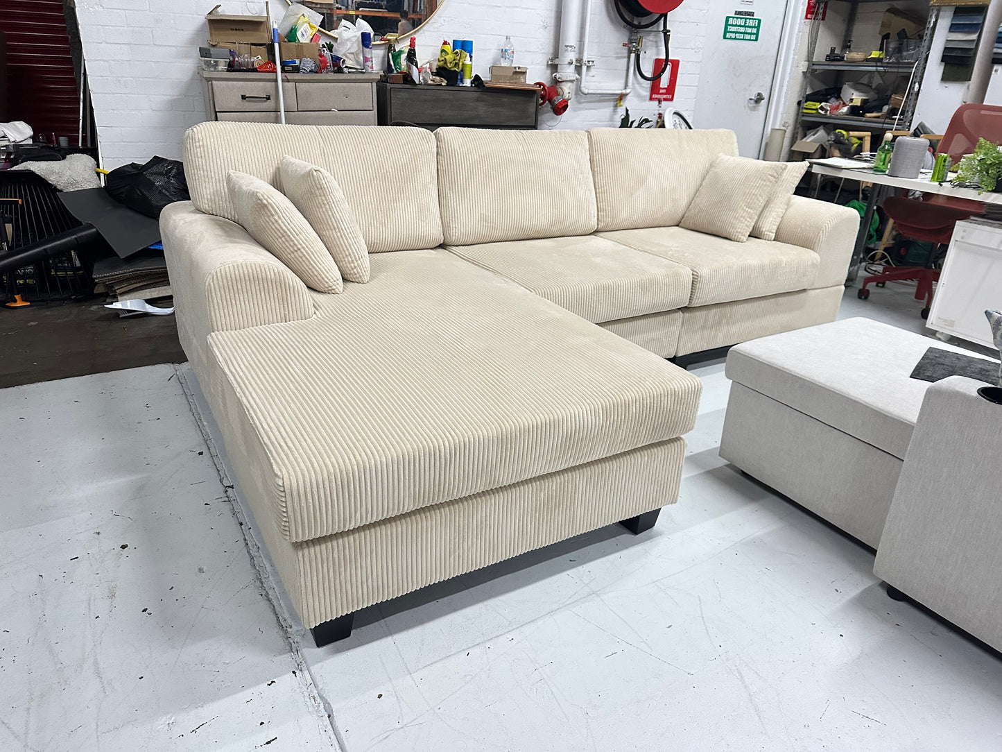 Cream color corduroy sofa and cream bed frame with mattress