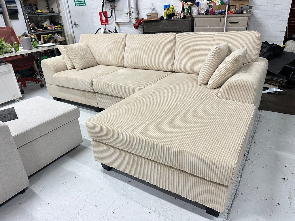 Cream color corduroy sofa and cream bed frame with mattress