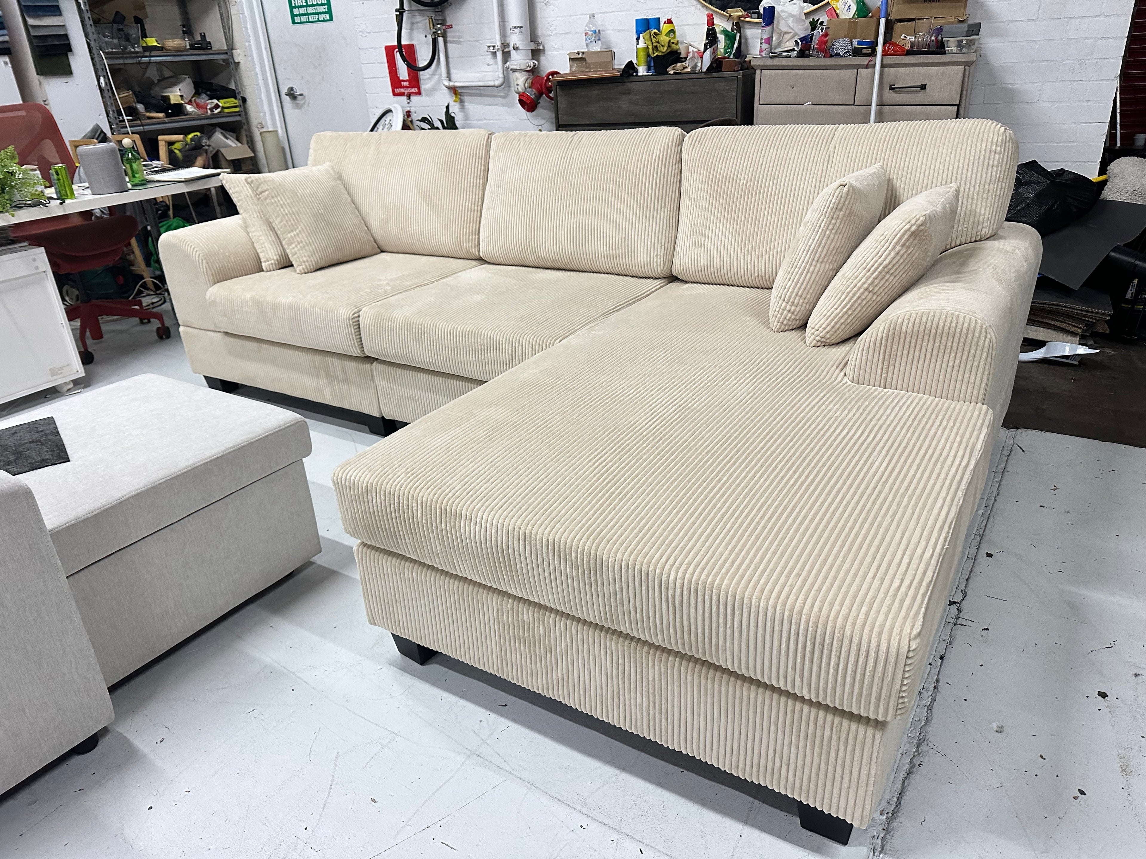 Cream color corduroy sofa and cream bed frame with mattress
